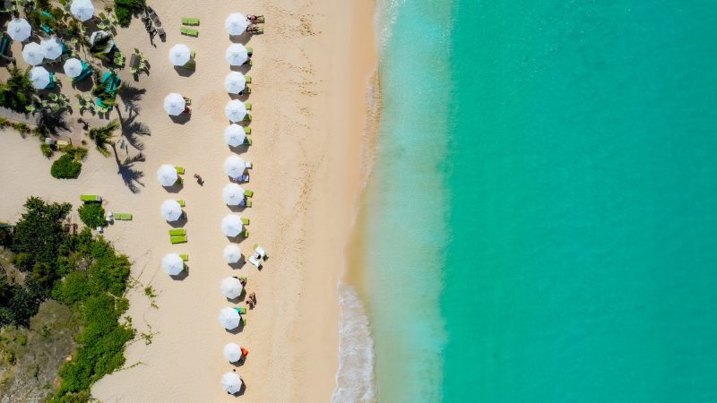 Caribbean Serenity: A Bird's-Eye View of Paradise, turquoise water, white sand and beach umbrellas.